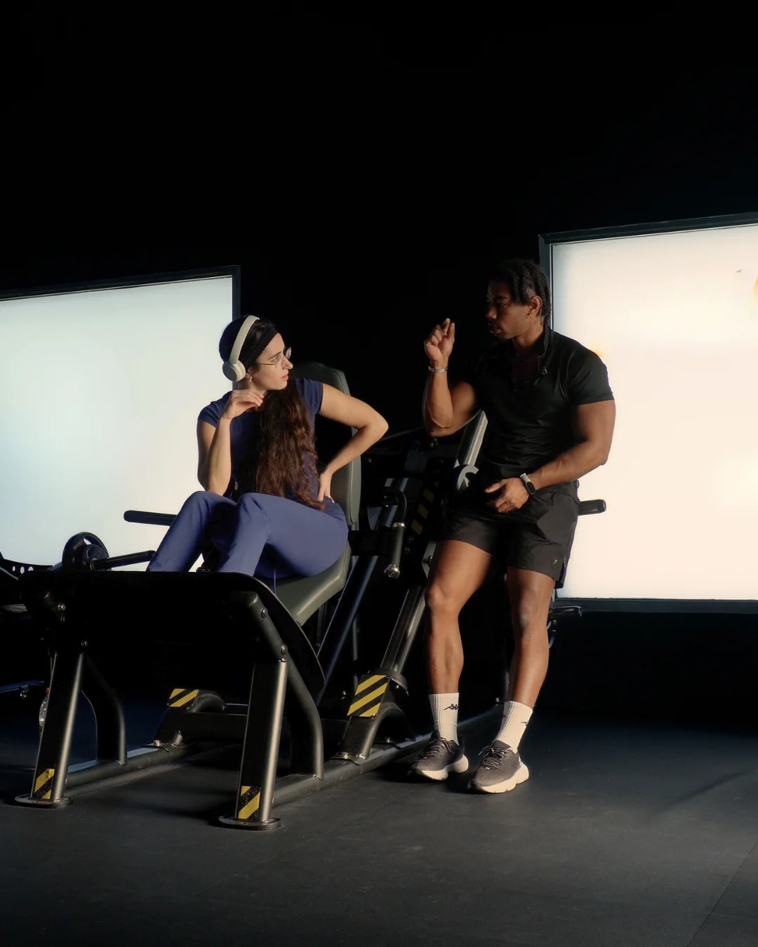Personal trainer discussing workout guidance with a client in Barcelona gym